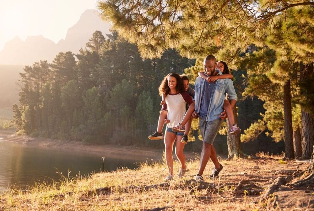 A group of people walking on the grass near trees.