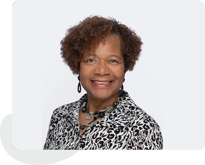 A woman with curly hair wearing a leopard print shirt.